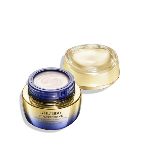 Open jar of Shiseido Vital Perfection Uplifting and Firming Advanced Cream with a gold to purple gradient finish. The gold lid sits behind the jar, revealing the cream inside.